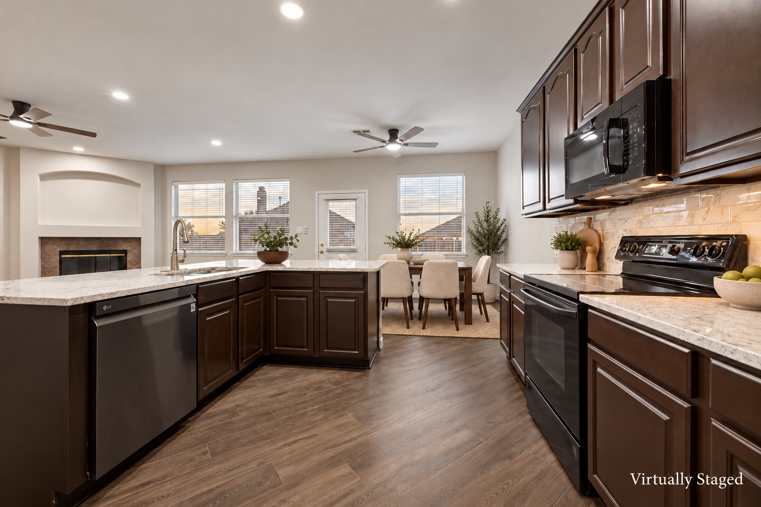 Virtually staged view of the kitchen at 4215 Maidstone Drive, viewed across the center island toward the breakfast area.