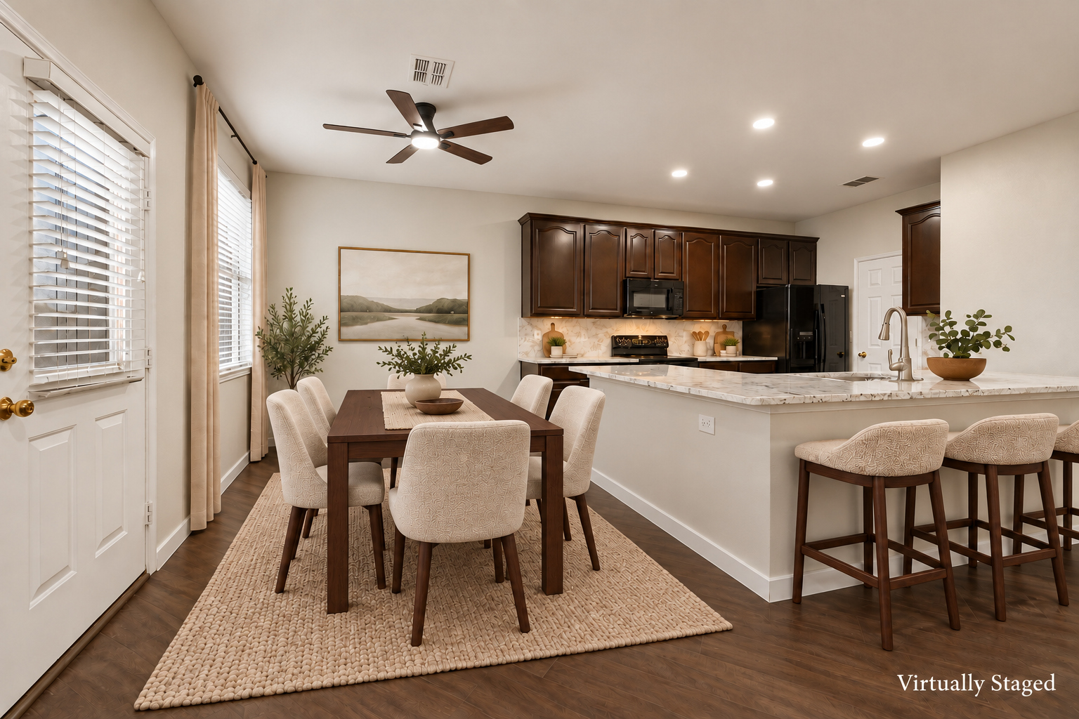 Virtually staged view of the kitchen and dining area at 4215 Maidstone Drive, showing the island with bar seating and a dining table.