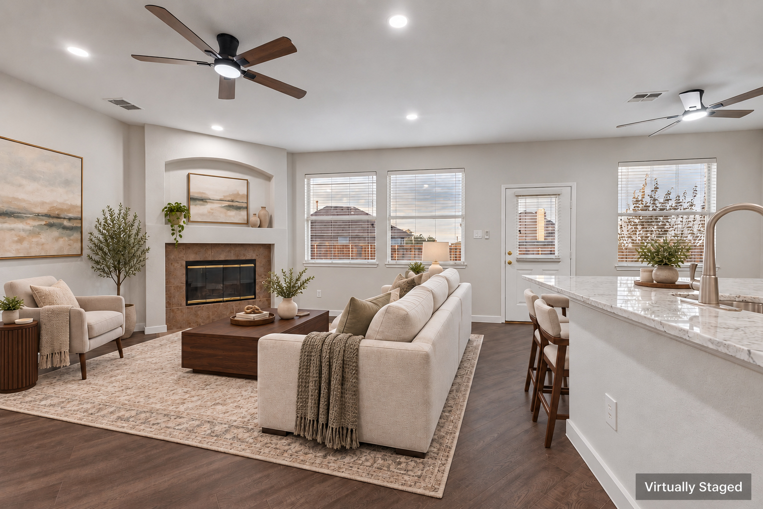 Virtually staged view of the living room with fireplace and island bar seating at 4215 Maidstone Drive.