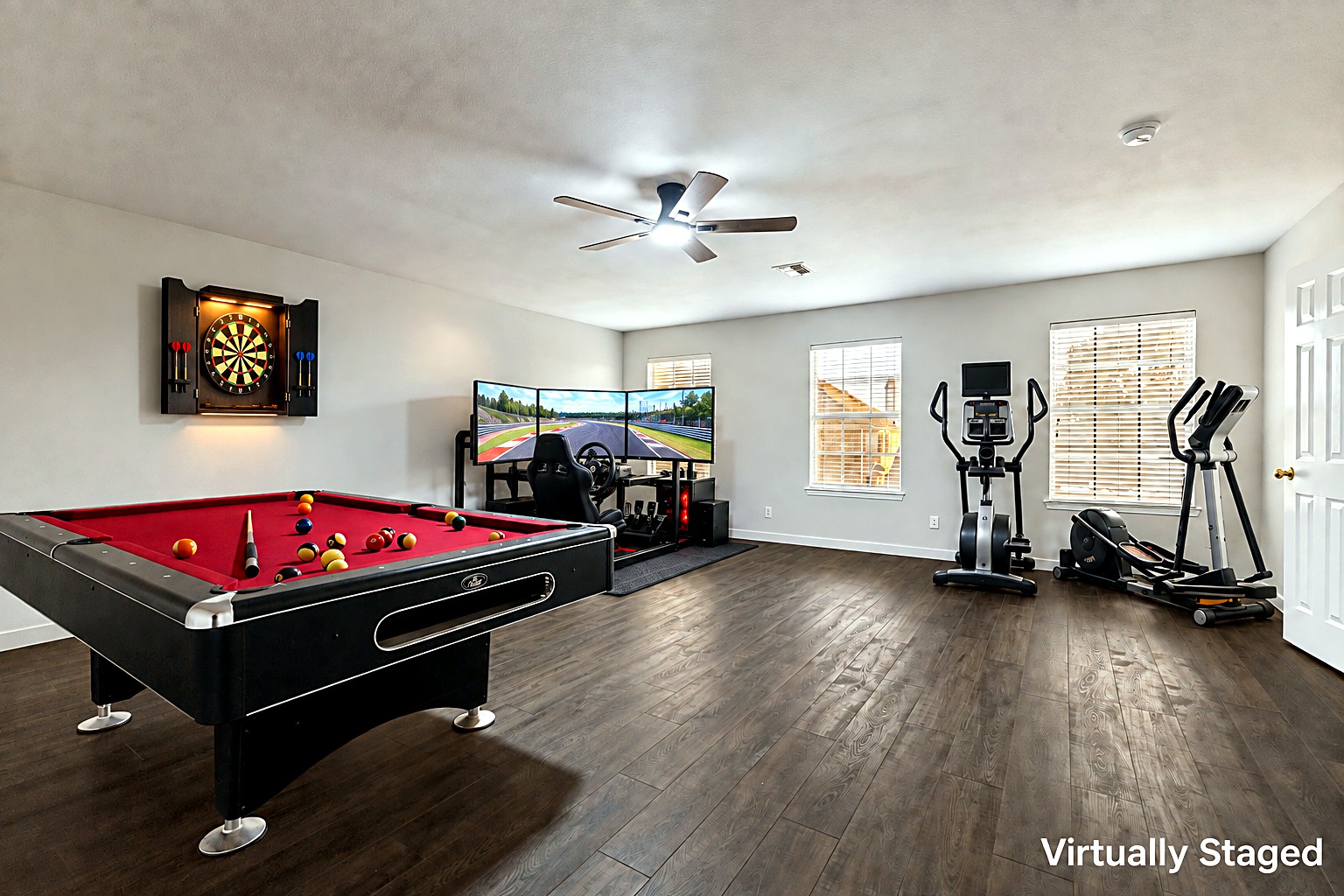 Virtually staged view of the game room at 4215 Maidstone Drive, showing the home's actual pool table, dartboard, racing simulator, and exercise equipment.